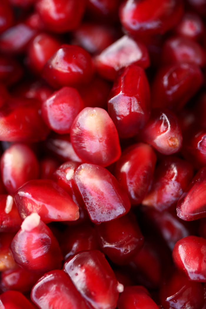 Explore the refreshing and healthy red pomegranate seeds with this vibrant close-up view.