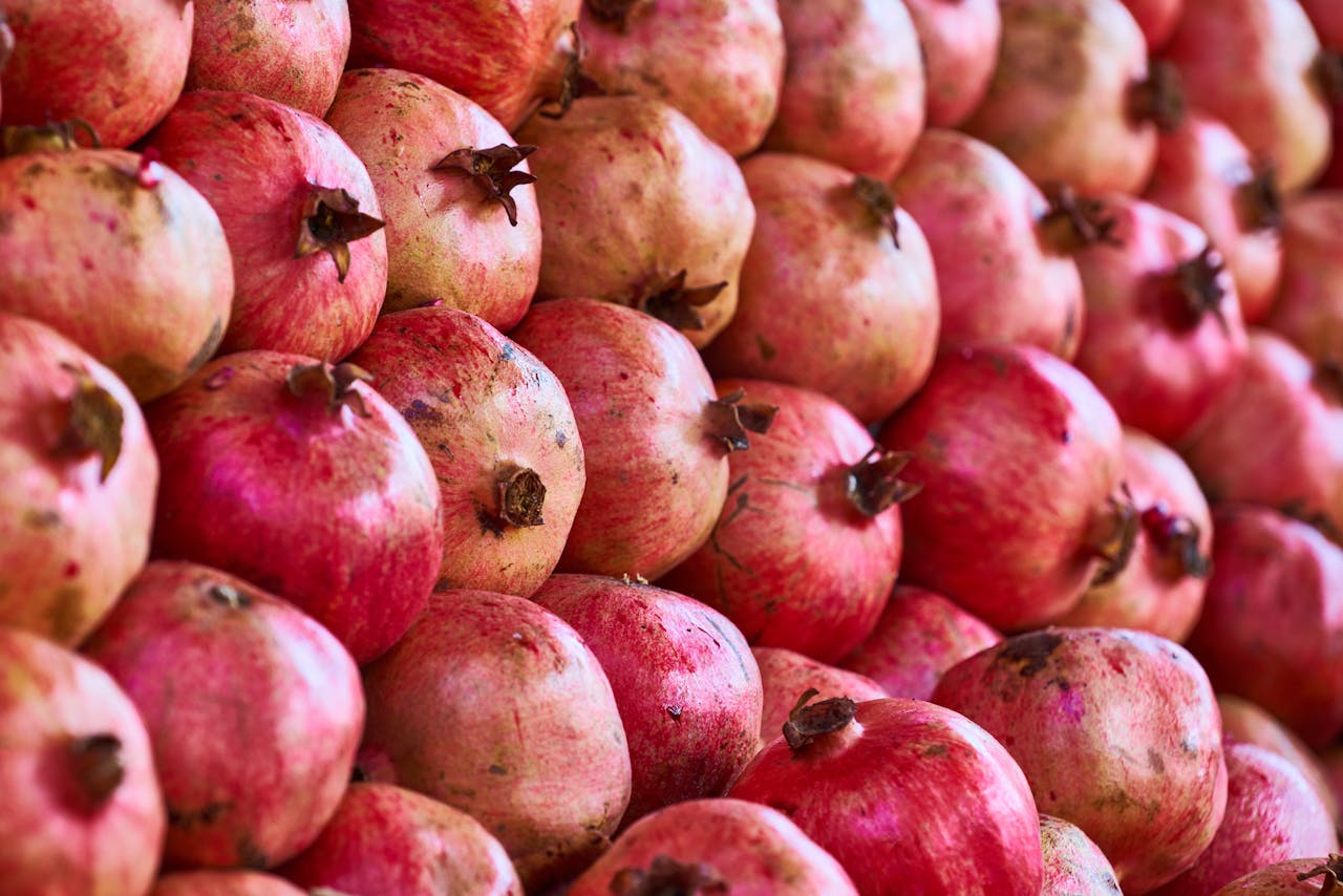 Close-up view of vibrant and ripe pomegranates displaying their organic texture and rich red colors.